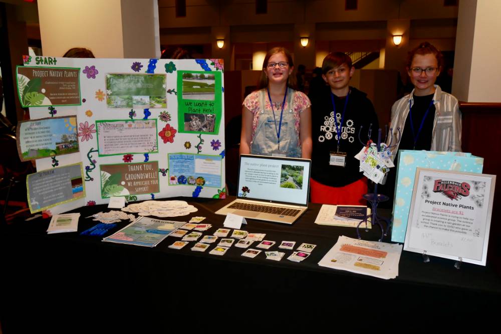 Oakwood Intermediate School students pose with their native plants poster and table